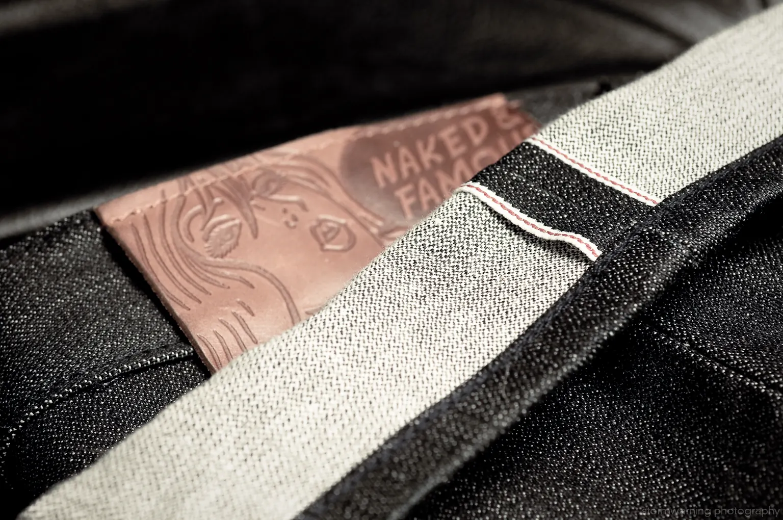 Close-up of a jeans cuff showing the clean selvedge edge of the denim