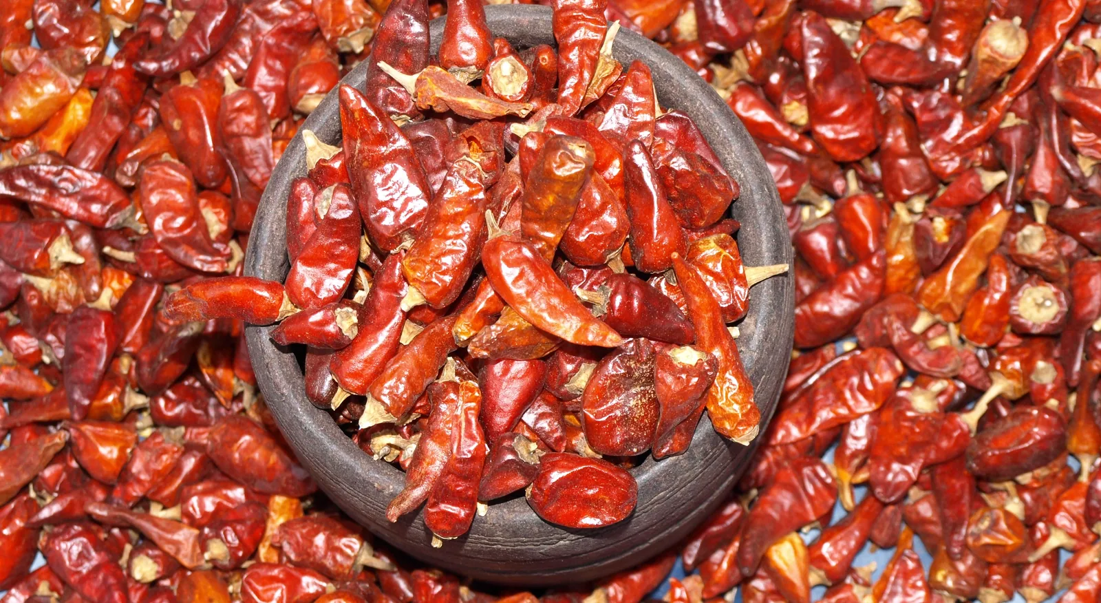 Dried red chillies heaped for sale by traditional measure in a Goa market
