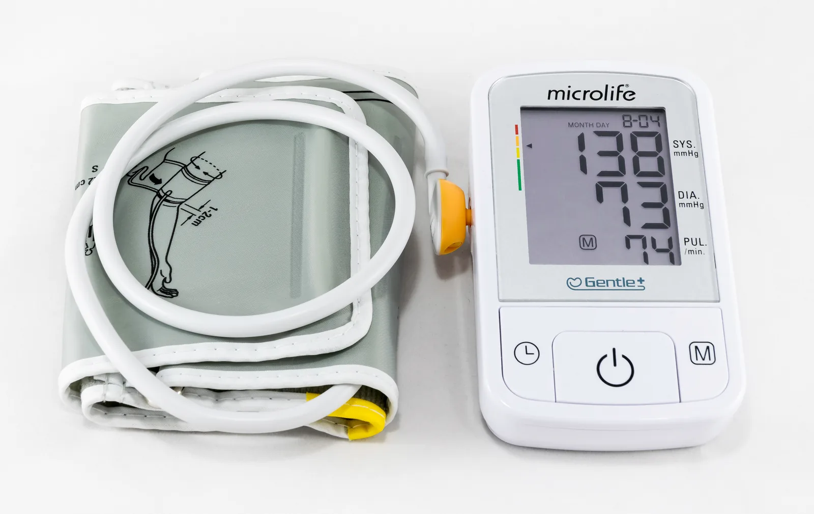 Electronic blood pressure monitor showing a reading of 138 over 73 mmHg with cuff attached