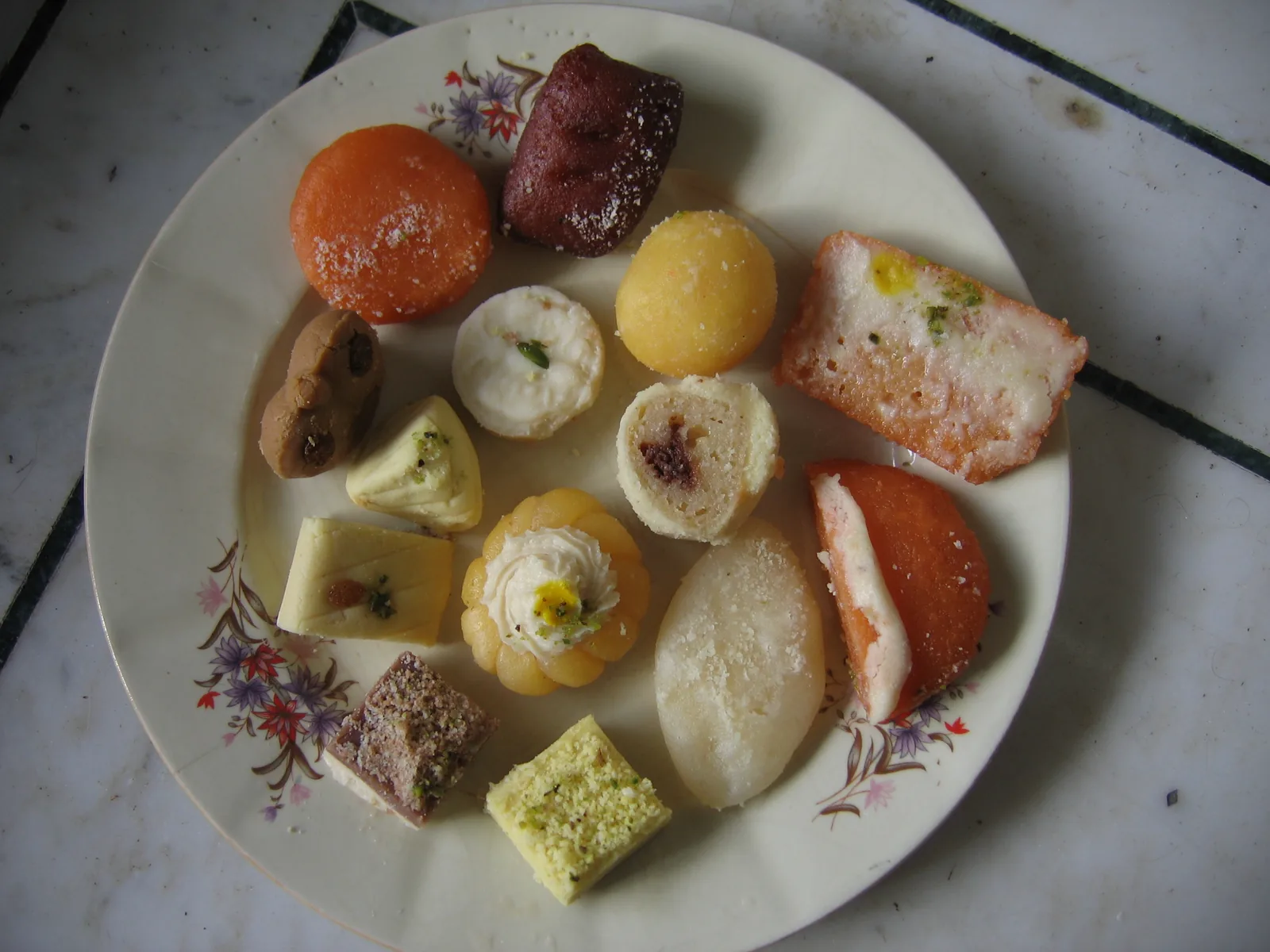 A plate filled with many varieties of colourful Indian mithai sweets