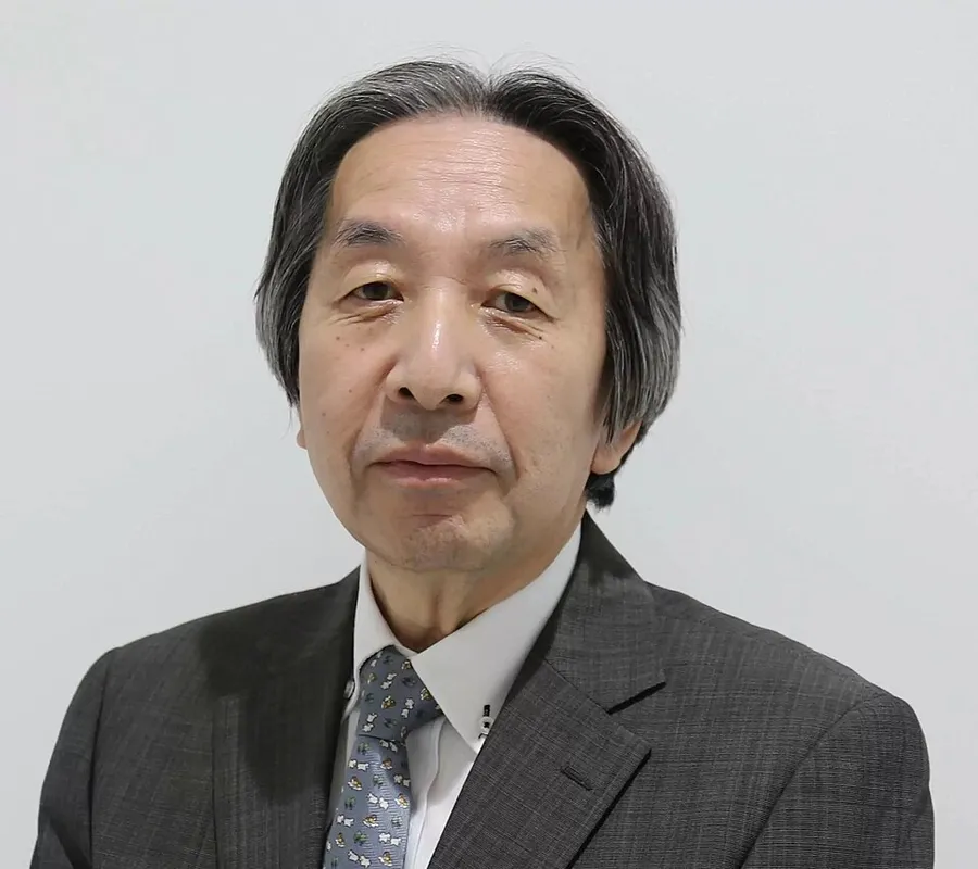 Portrait of Masahiro Hara, the engineer who led the development of the QR code, wearing a dark suit and patterned tie