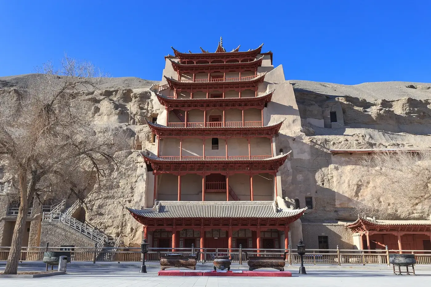 The red multi-storey pagoda façade of the Mogao Caves set into a cliff near Dunhuang