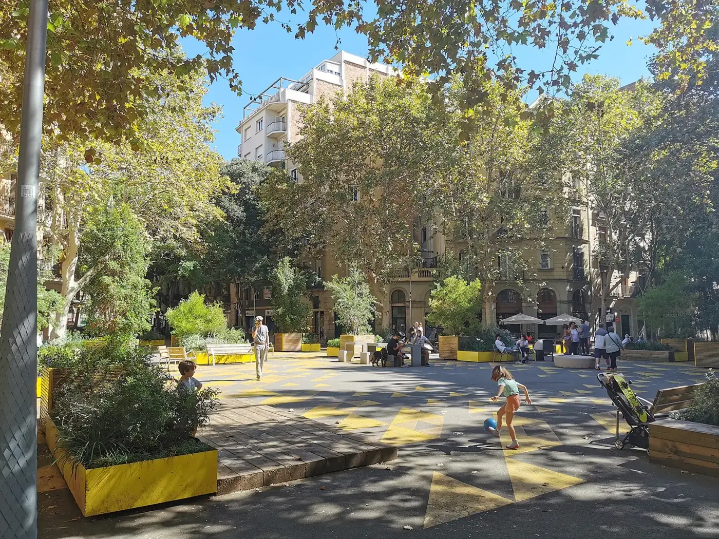 A tree-lined Barcelona street turned into a pedestrian superblock with benches and planters