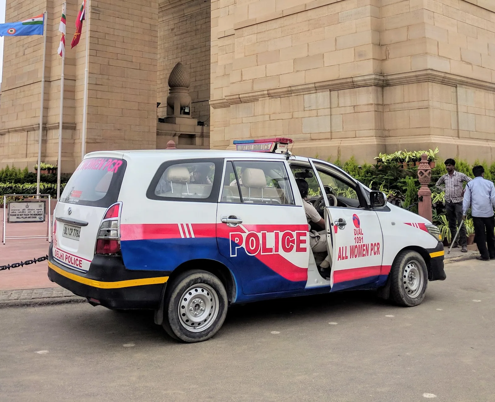 A white Delhi Police All Women PCR Toyota Innova parked near India Gate