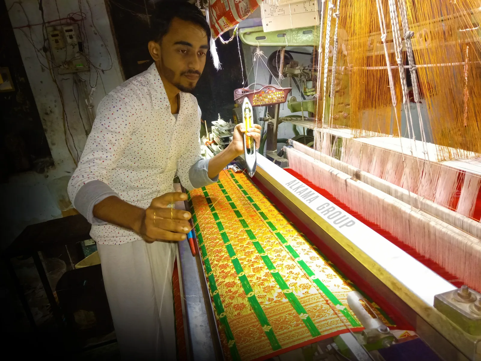 Banarasi saree weaver seated at a pit loom, working silk and zari threads by hand