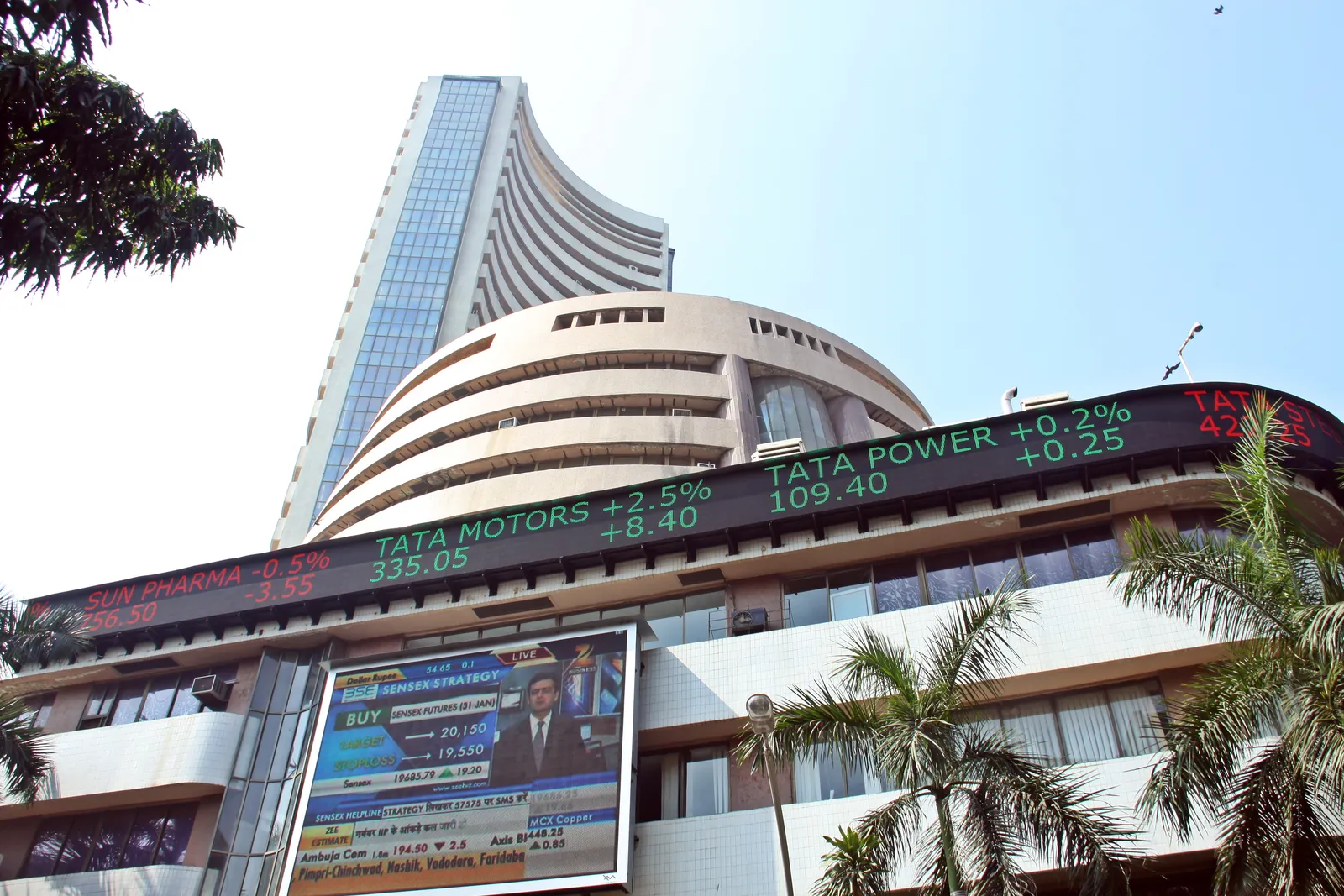 The curved Phiroze Jeejeebhoy Towers of the Bombay Stock Exchange on Dalal Street, with a scrolling share price ticker across its lower floors