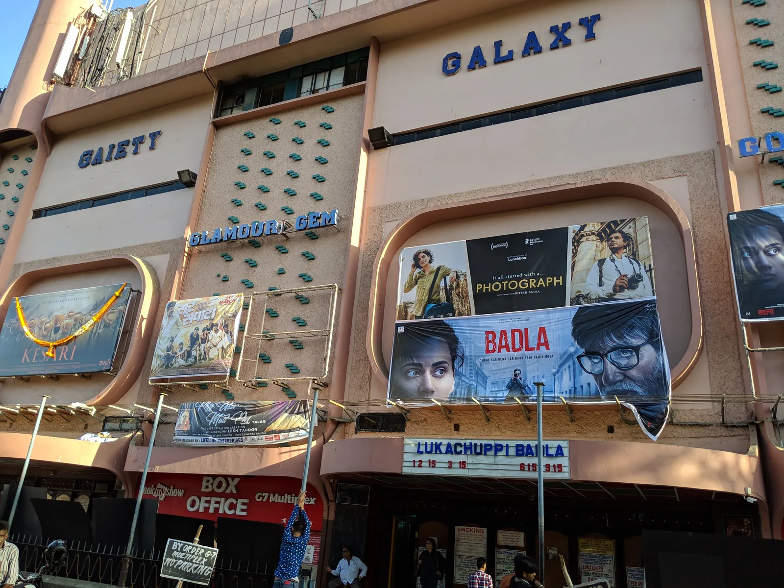 Street-level facade of the G7 Multiplex Gaiety Galaxy cinema in Bandra, Mumbai, with red and yellow signage and posters above the entrance