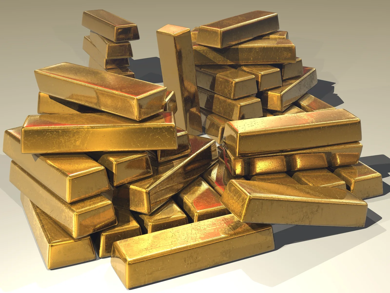 Several rectangular gold bullion bars stacked closely, showing stamped surfaces and reflective yellow metal