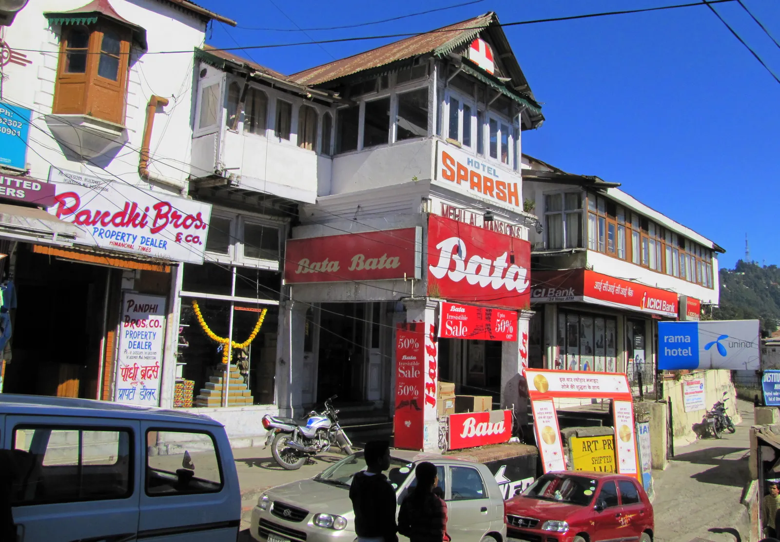 A Bata shoe store with red signboards and a 50 percent sale banner on a hillside street in Kulri Bazaar, Mussoorie