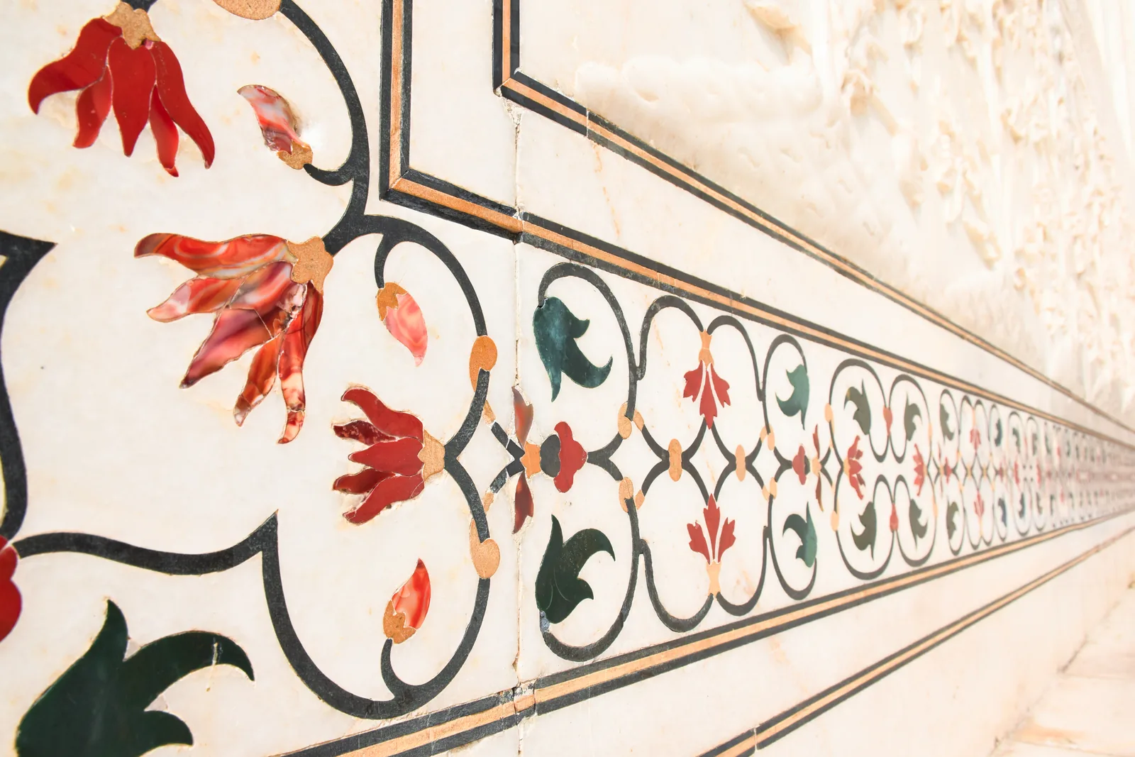Close view of floral pietra dura inlay in white Makrana marble on the Taj Mahal, with semi-precious stone petals and leaves